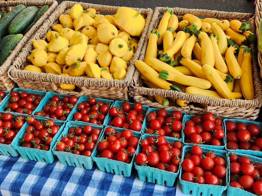 A display of yellow squashes and red cherry tomatoes at the Bellingham Farmers Market.