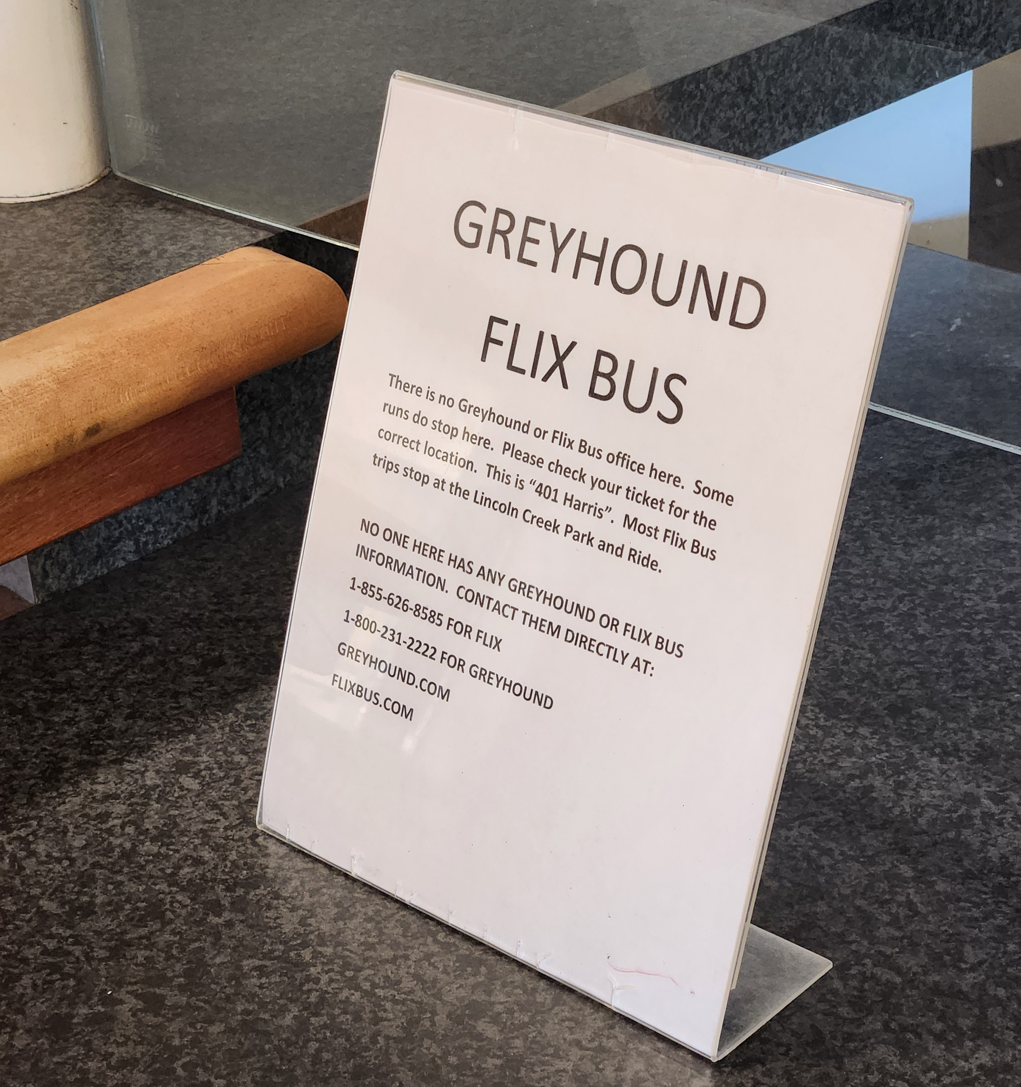 A sign reading: "There is no Greyhound or Flix Bus office here. Some runs do stop here. Please check your ticket for the correct location. This is "401 Harris". Most Flix Bus trips stop at the Lincoln Creek Park and Ride."  "NO ONE HERE HAS ANY GREYHOUND OF FLIX BUS INFORMATION."