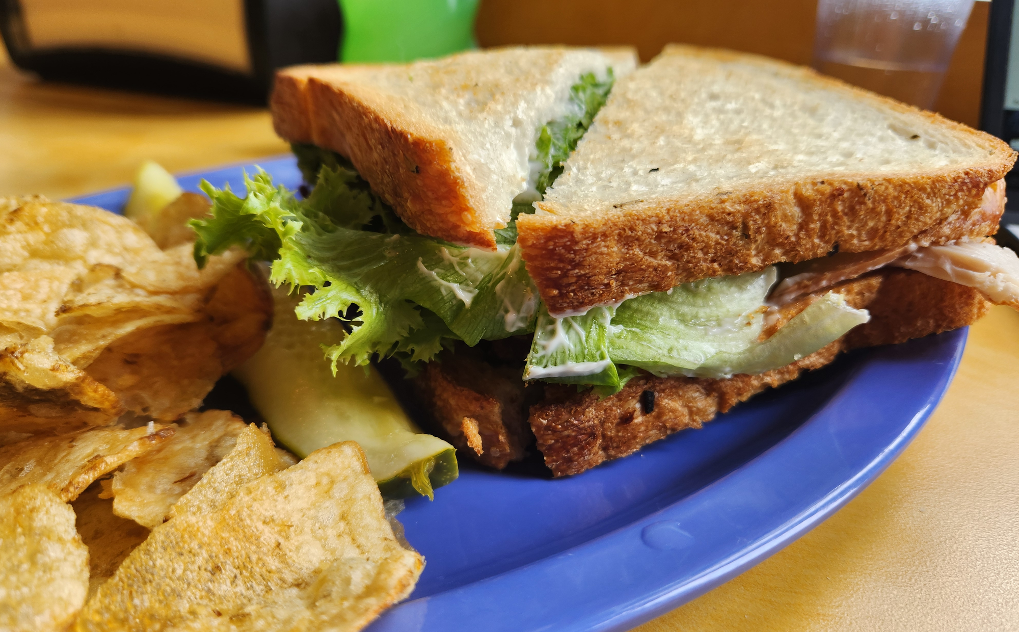 A lunch plate with a sandwich and potato chips. 