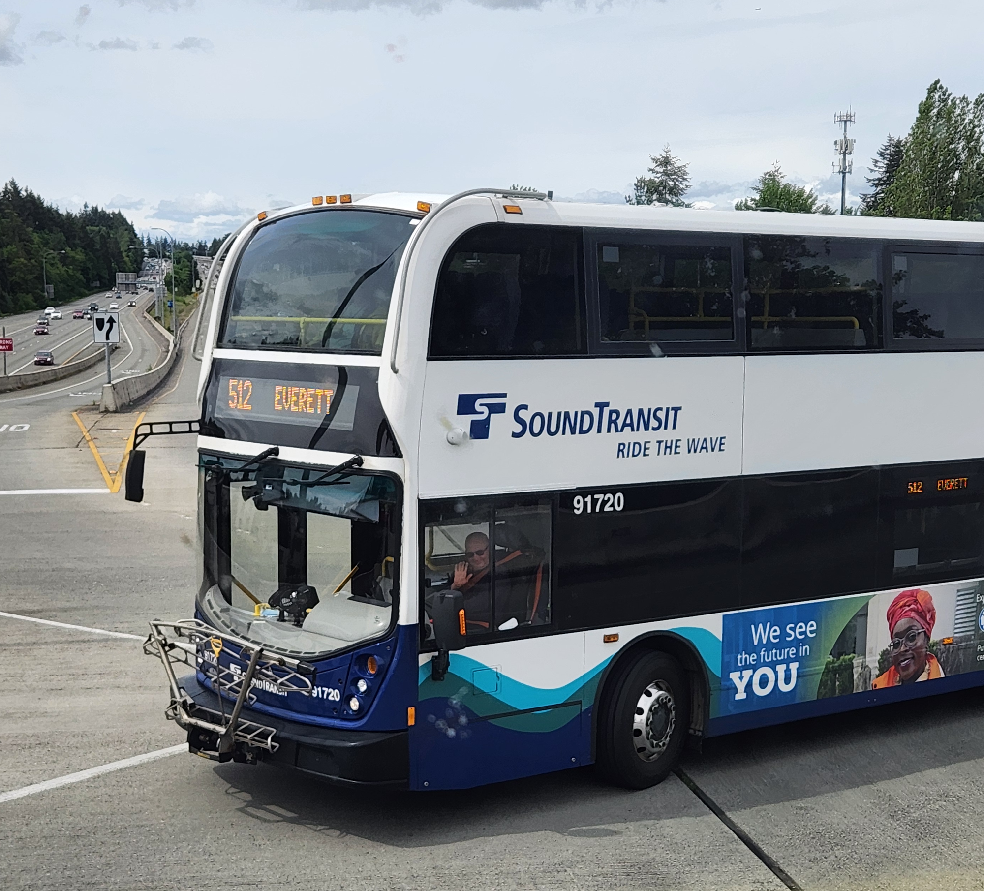 A double-decker Sound Transit Express Route 512 bus turning from the Lynnwood City Center Station onto an onramp leading to Interstate 5's HOV lanes. 