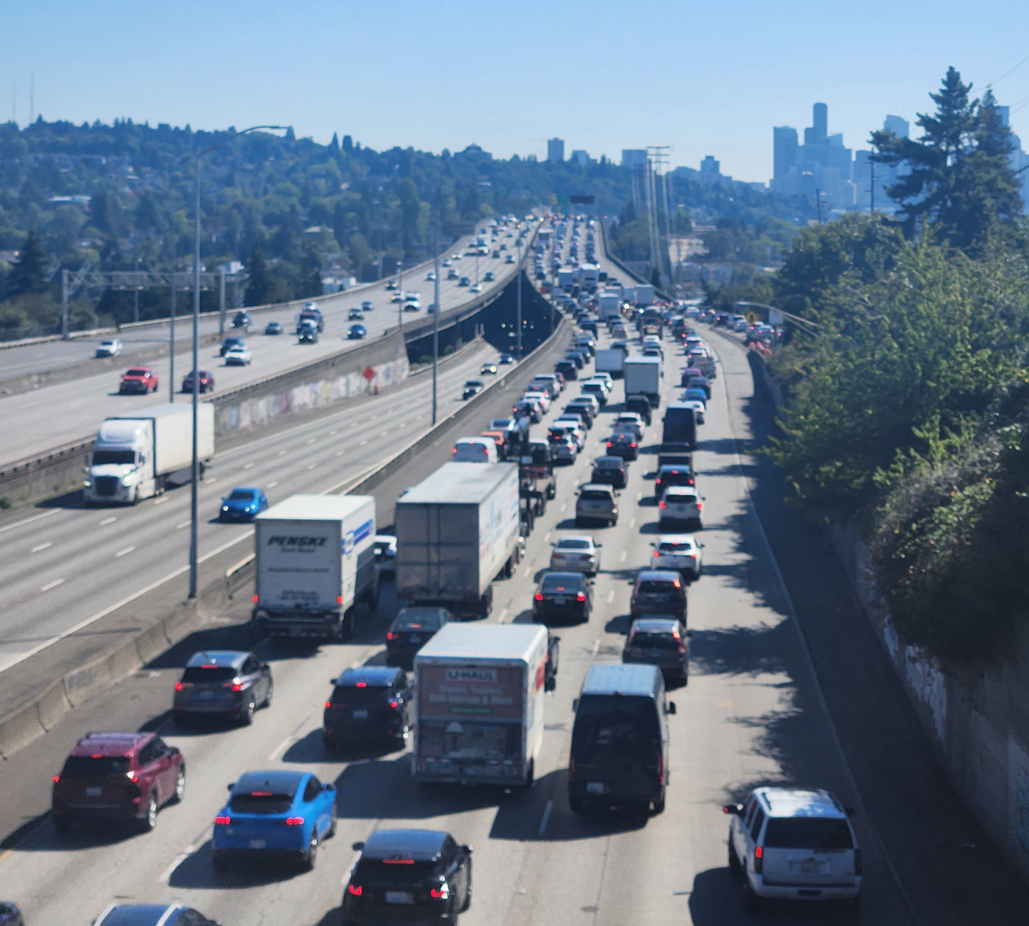 Heavy congestion on southbound Interstate 5 with the Downtown Seattle skyline in the distance.