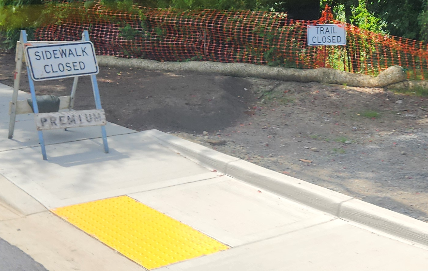 "Sidewalk Closed" and "Trail Closed" signs are posted near construction work to build new sidewalks and curb cuts.